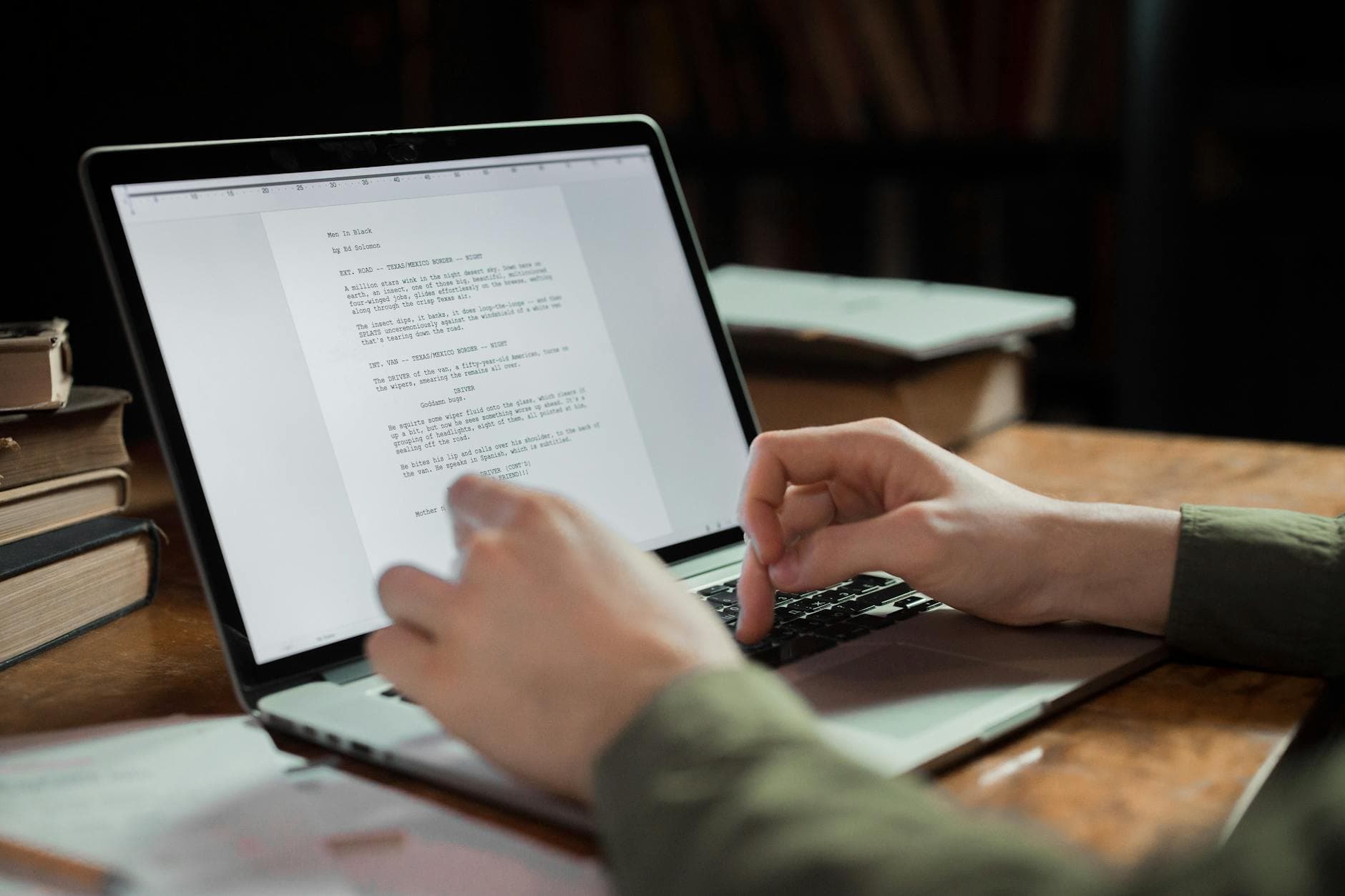 Hands typing on a laptop displaying a script, part of a faceless YouTube creator's workflow.