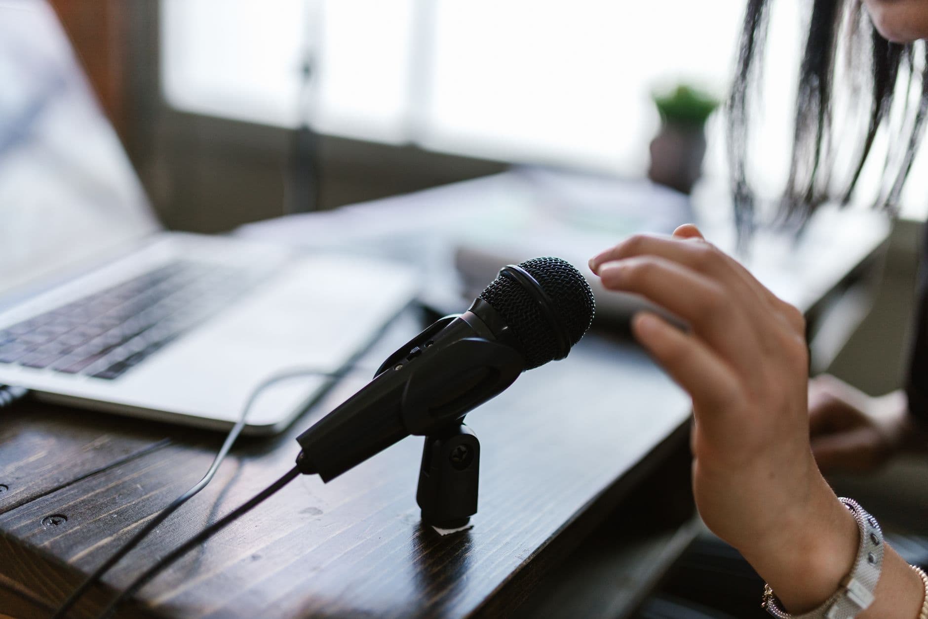 Faceless creator's hands adjusting audio mixer for video production workflow.