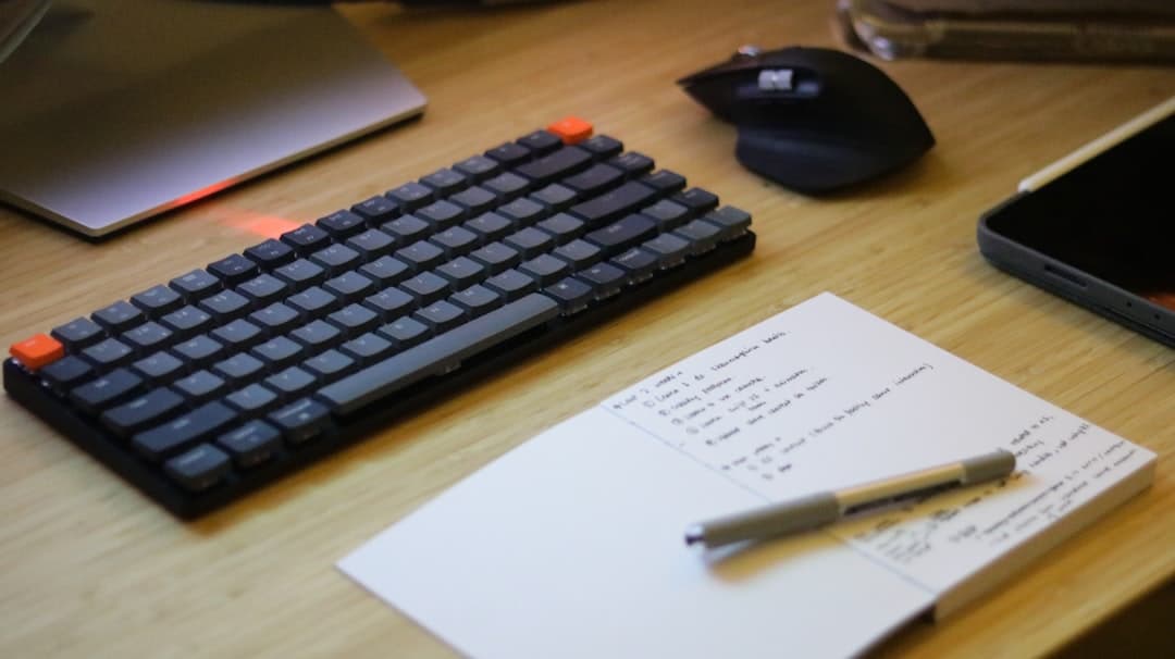 Faceless YouTube creator's desk with keyboard, notebook, and mouse for content planning.