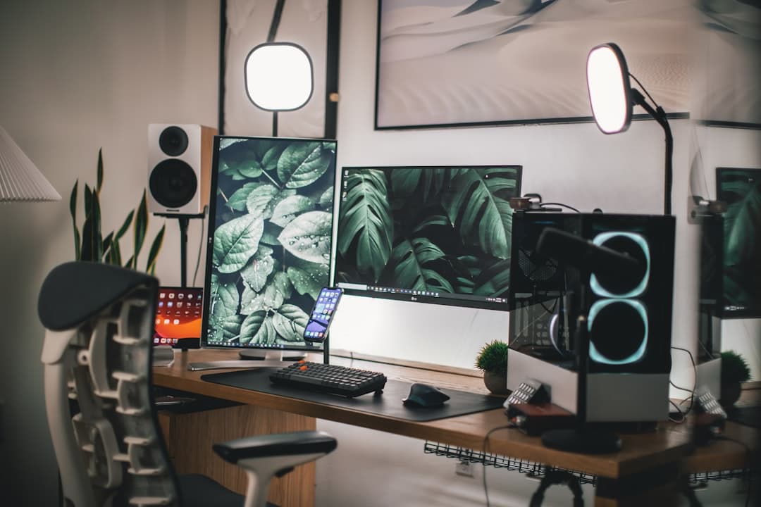 Faceless YouTube creator's dual monitor setup with plants and studio lighting for content creation.