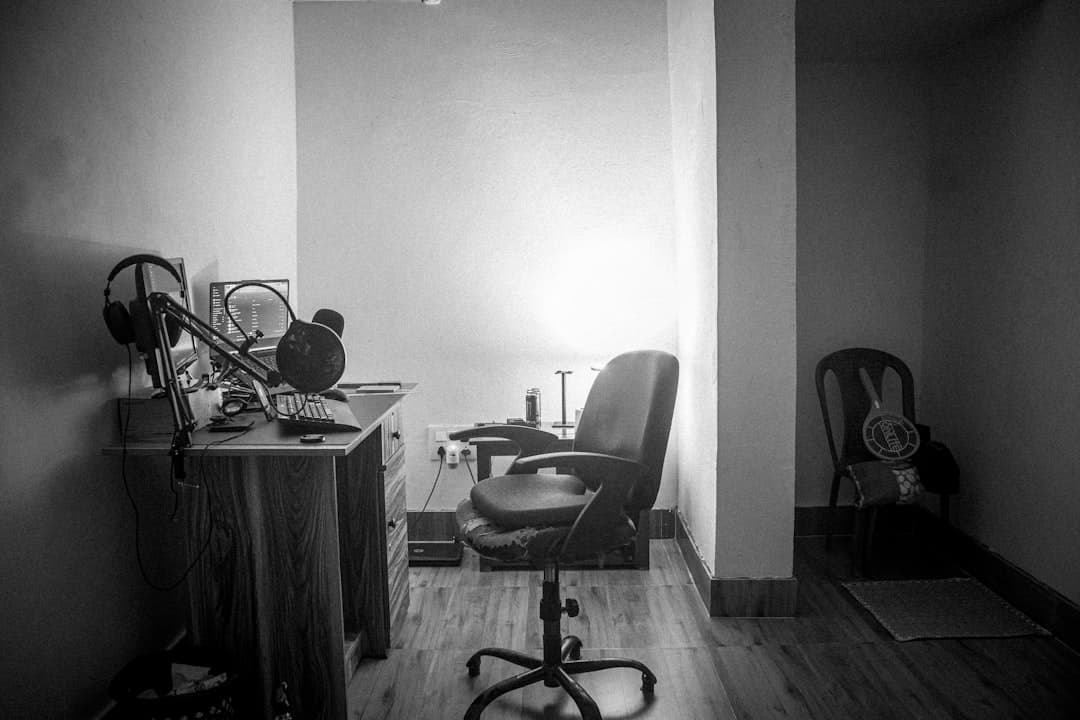 Faceless YouTube creator's studio setup with microphone, headphones, and computer monitor.