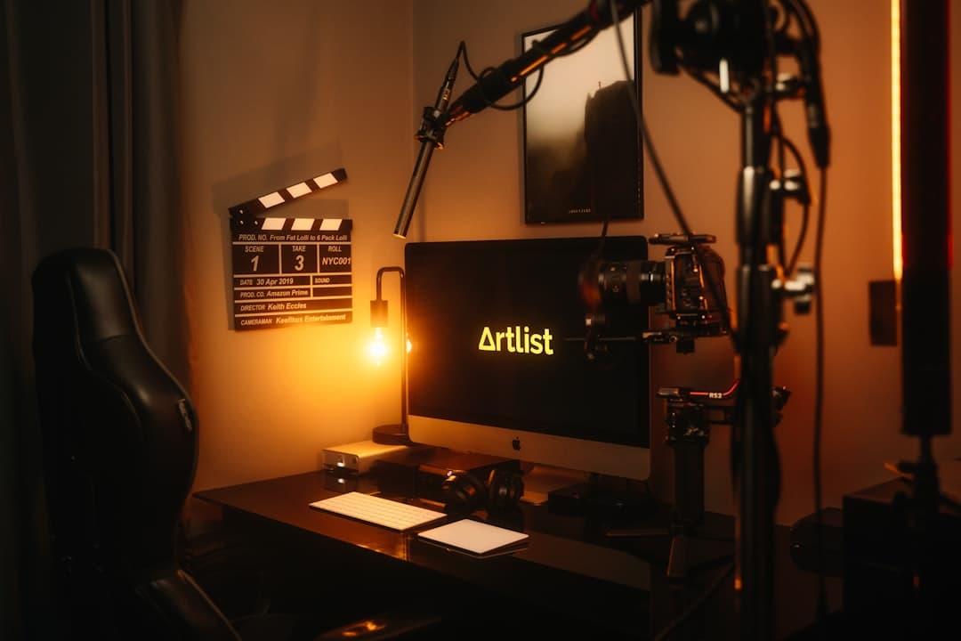 Faceless YouTube creator's desk with computer, microphone, and camera equipment for AI channel audits.