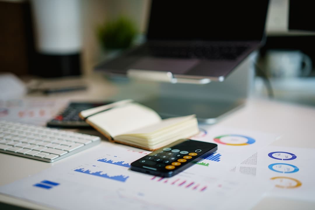 Faceless YouTube creator's desk with laptop, charts, and calculator for AI cost audit.