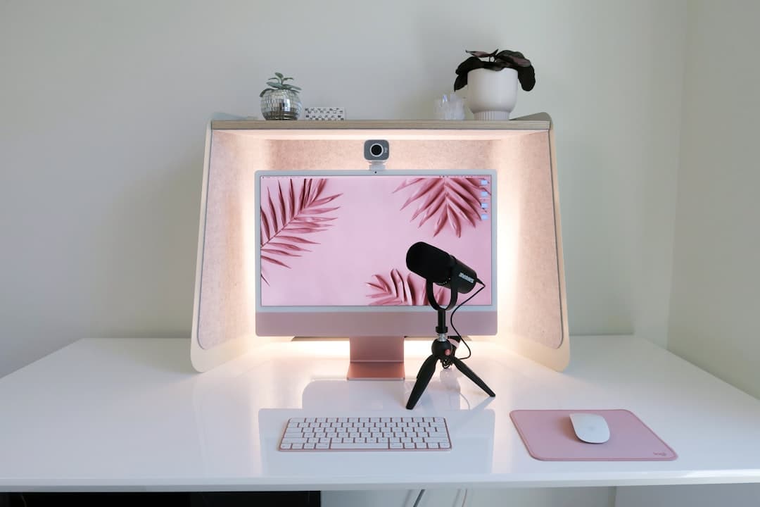 Clean home studio desk with iMac, microphone, and ring light for faceless YouTube content creation.