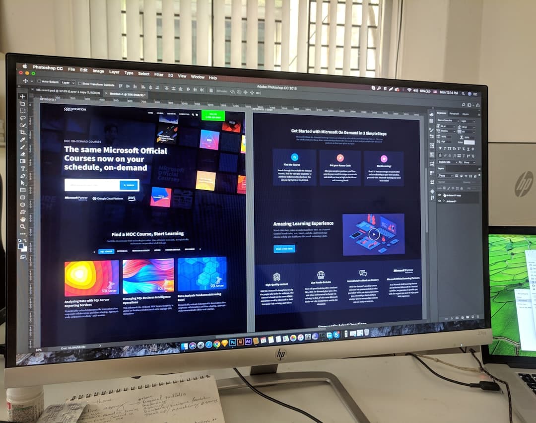 Computer monitor displaying Adobe Photoshop with website design for Microsoft courses.