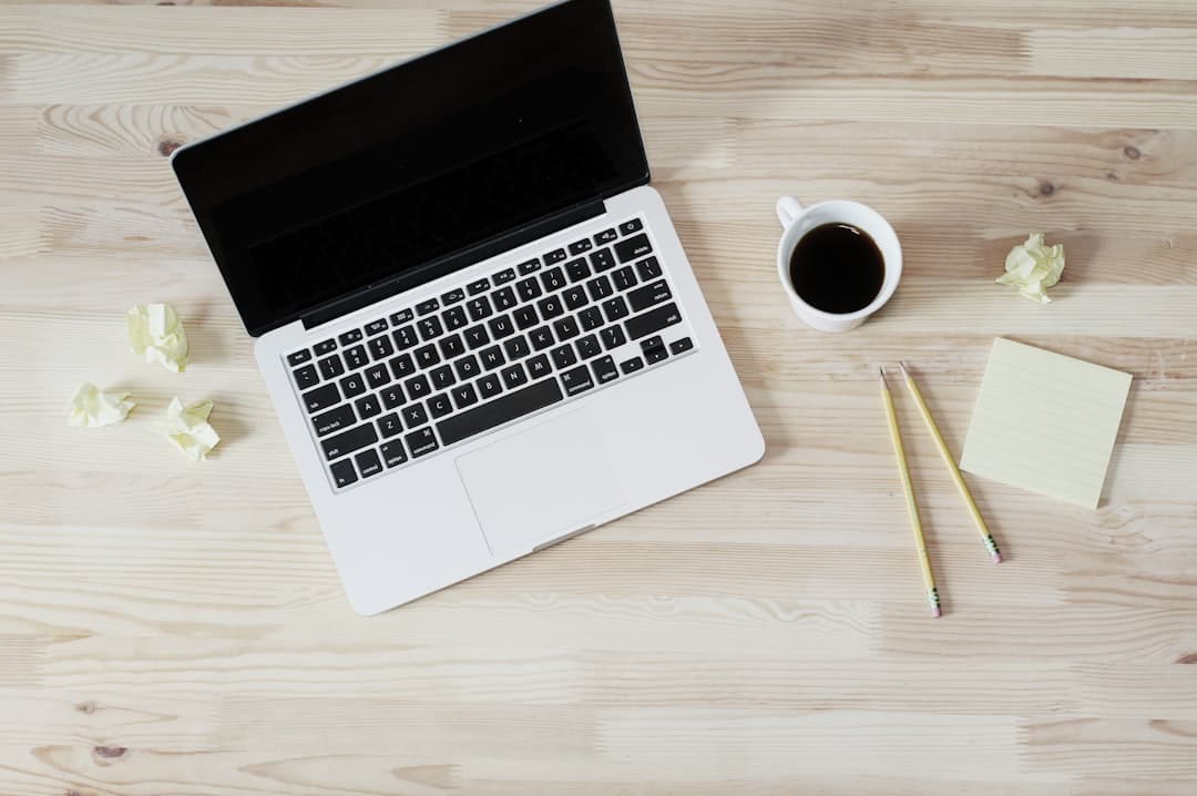 Faceless YouTube creator's desk with laptop, coffee, and notes for AI content strategy.