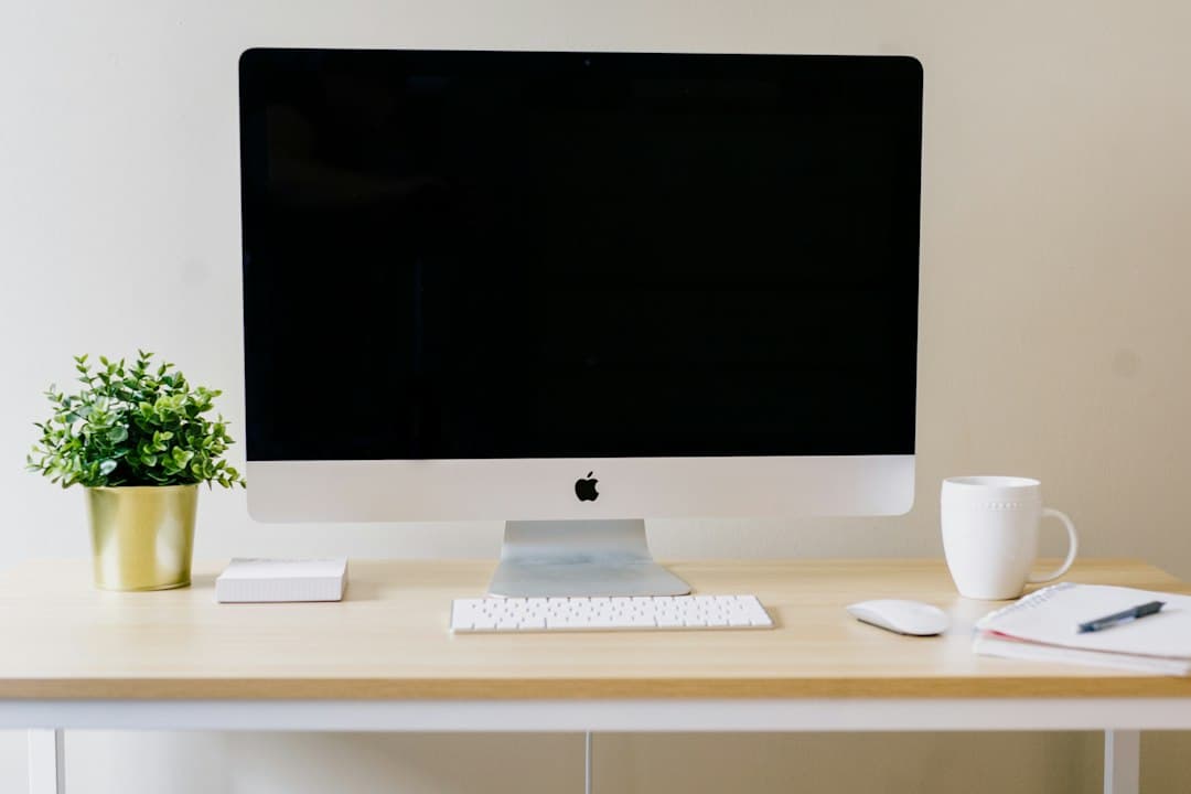 Faceless YouTube creator's desk with computer, keyboard, and plant for content strategy planning.