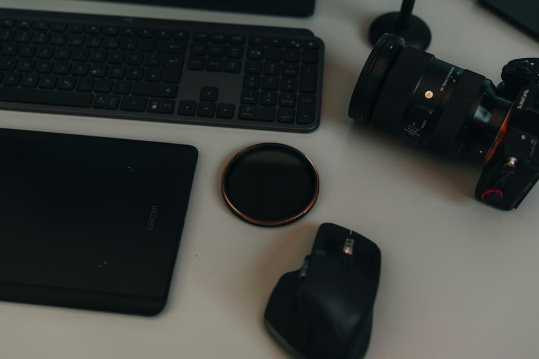 Faceless YouTube creator's desk with camera, keyboard, and tablet for video production.