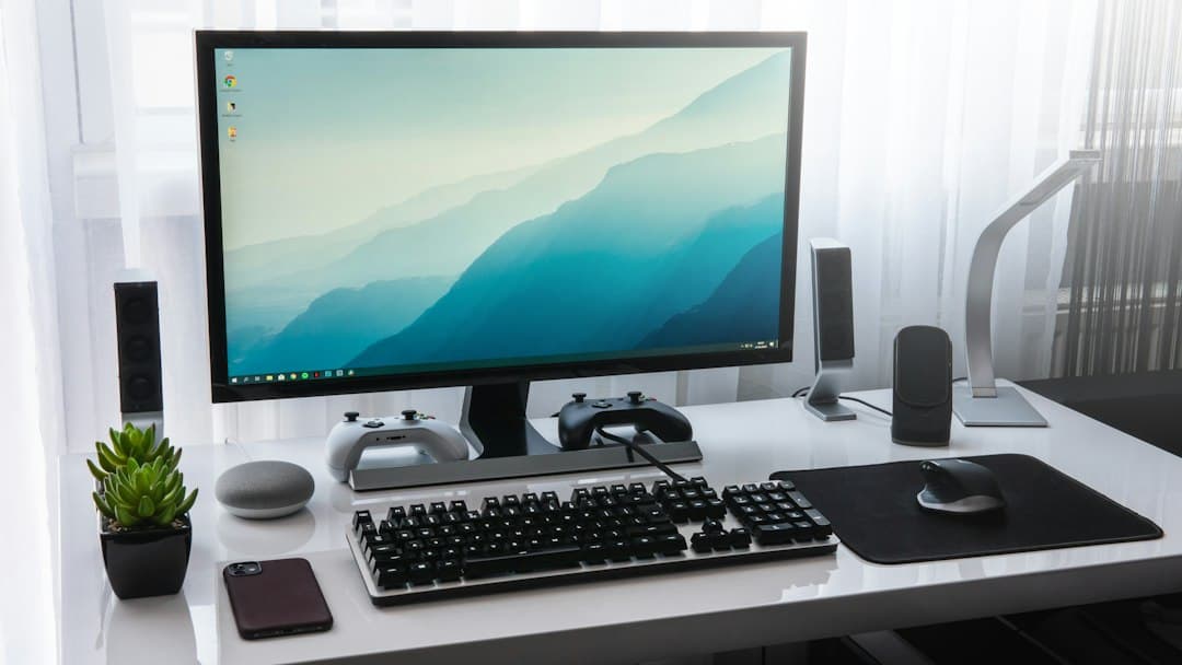 Faceless YouTube creator's desk setup with monitor displaying nature wallpaper and audio equipment.