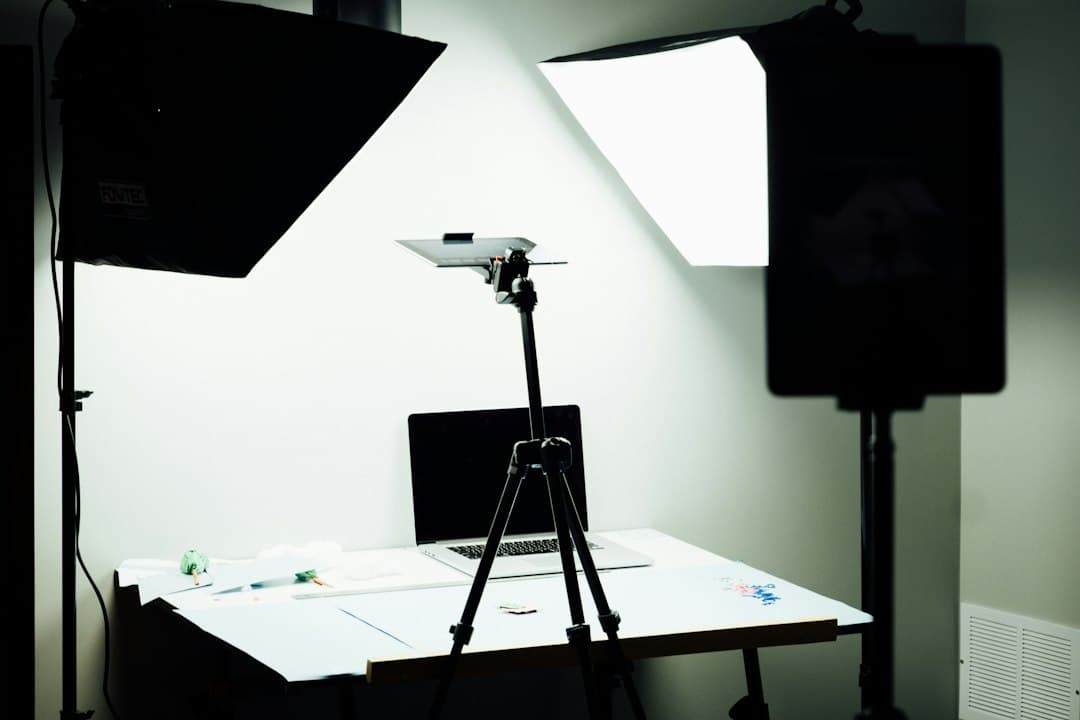 Faceless YouTube creator's studio setup with laptop and lighting for content analysis.